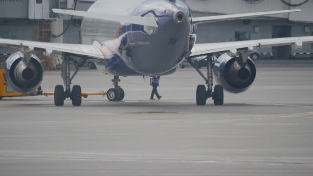 在谢列梅捷沃机场，一架空中客车A320被橙色拖轮反推视频素材