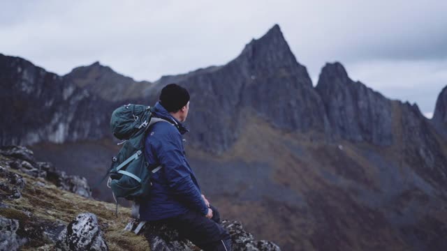 背包徒步旅行者坐在风景中视频素材