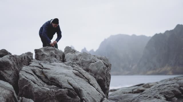 峡湾岩石旁的徒步旅行者拿着相机视频素材