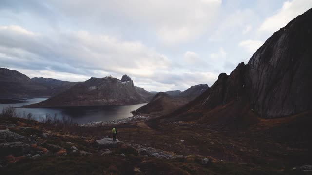 徒步旅行者站在岩石上看峡湾和山脉视频素材