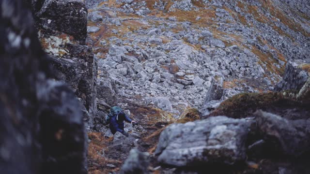 在山上攀登岩石的徒步旅行者视频素材