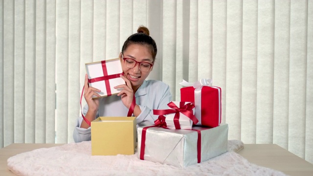 女人手里拿着一件蓝衬衫和礼盒，为节日赠送特殊节日如圣诞节、新年、情人节的礼物视频下载