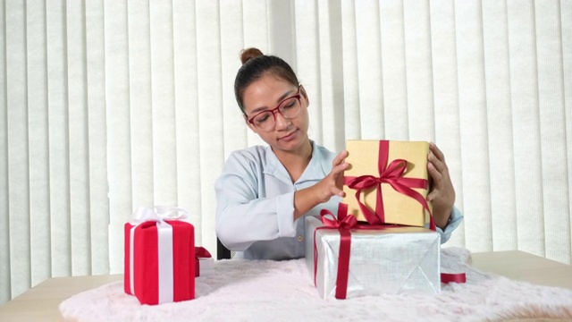 女人手里拿着一件蓝衬衫和礼盒，为节日赠送特殊节日如圣诞节、新年、情人节的礼物视频素材