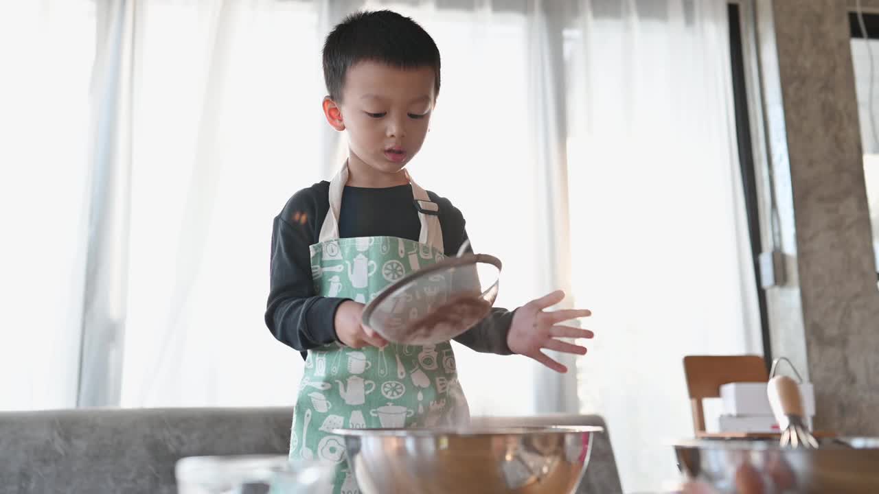 亚洲快乐可爱的男孩玩和烘培在家庭厨房有趣。自制食物和面包。教育与学习理念。泰国人视频下载