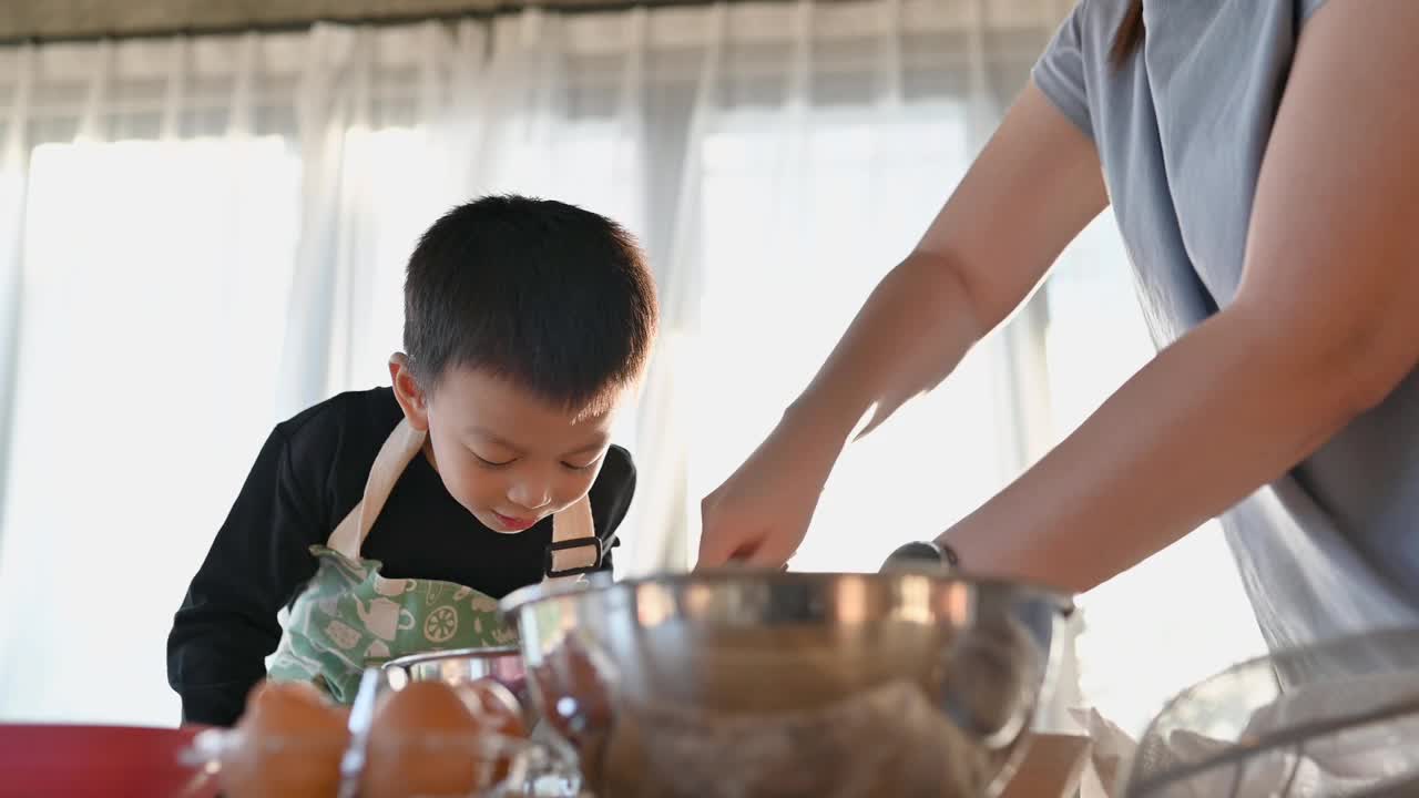 亚洲快乐可爱的男孩玩和烘培在家庭厨房有趣。自制食物和面包。教育与学习理念。泰国人视频下载