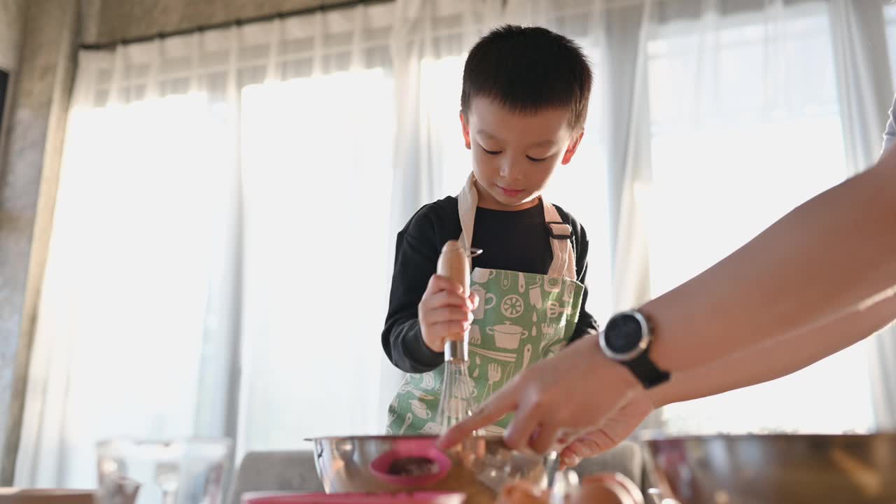 亚洲快乐可爱的男孩玩和烘培在家庭厨房有趣。自制食物和面包。教育与学习理念。泰国人视频下载