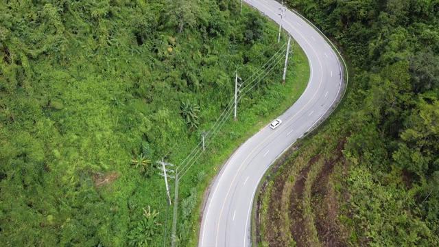 鸟瞰图的一辆汽车沿着山路通过热带森林在农村由无人机视频素材