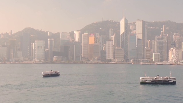 迷人的天星小轮在香港维多利亚港平静的水面上巡航，背景是高楼大厦视频素材