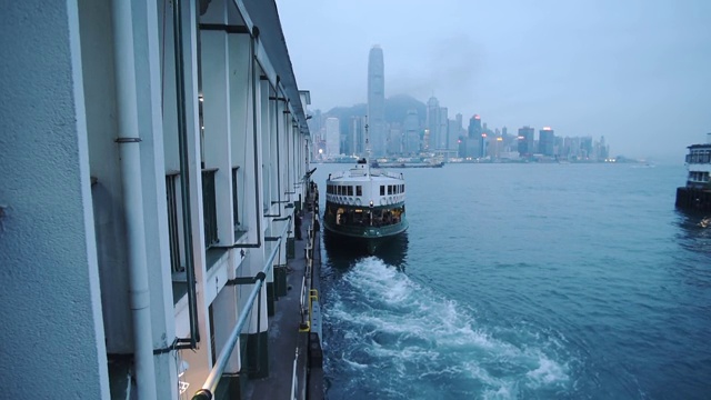 天星小轮在香港维多利亚港九龙码头的水面上留下痕迹。——广角镜头视频素材