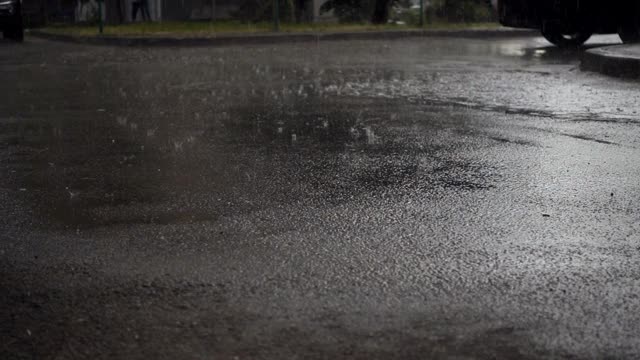 雨水以慢动作落进一个黑暗的水坑里视频素材