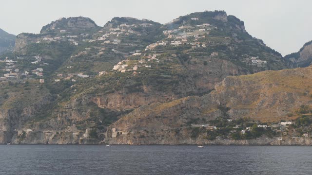 漂浮在海岸的岩石山上。山坡上陡峭山坡上的房子视频素材