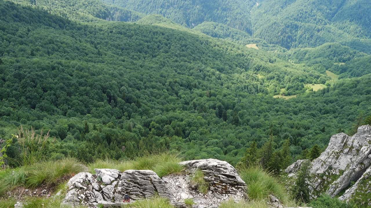 活跃的徒步女孩站在岩石的边缘看山的全景视频素材