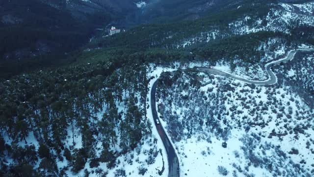 无人机拍摄的美丽雪山冬季弯弯曲曲的道路视频素材