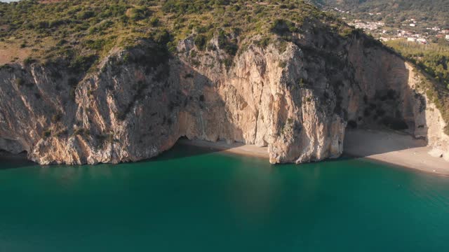 接近僻静的海滩和岩洞在陡峭的悬崖上的蓝色海洋。Palinuro、意大利视频素材