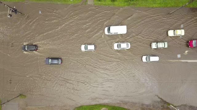 交通车辆在被雨水淹没的道路上行驶的鸟瞰图。视频素材