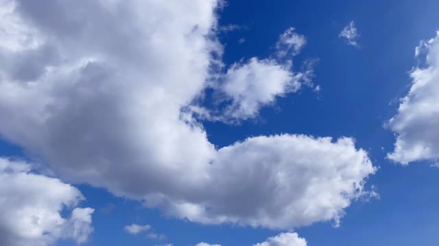 透明的白云在蓝色的天空中慢慢地漂移的延时镜头。Cloudscape。视频素材