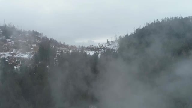 飞过意大利白云石山的薄雾，飞向白雪皑皑的阿尔卑斯村庄视频素材