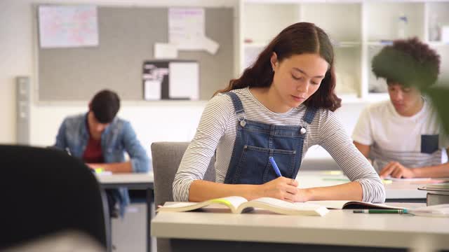 快乐的女学生在课堂上看着摄像机视频素材