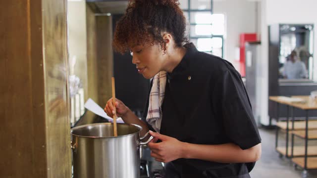 混血女厨师在锅里煮菜视频素材