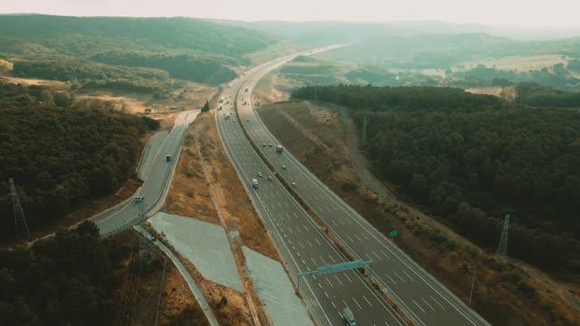 4K空中公路附近的山谷景观，而卡车和汽车通过它视频素材