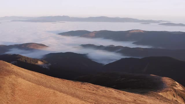 山坡的背景是山谷中的低云。视频素材