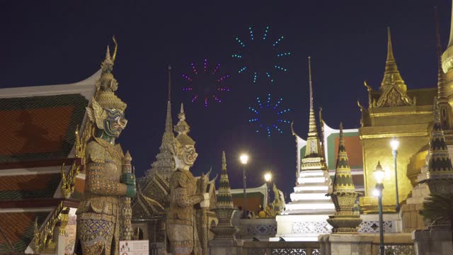 无人机在泰国曼谷翡翠佛寺金塔守护雕像前燃放烟花。佛寺和大皇宫在旧城，城市。泰国的佛教寺庙。视频素材