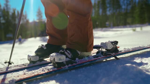 高山滑雪者在山上跨入滑雪绑定的特写视频素材