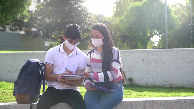 一群朋友在大学校园里一起学习，一起玩，都戴着防护口罩视频素材