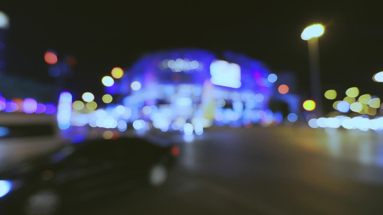 城市交通十字路口夜间车灯散景环光和失焦背景。视频素材