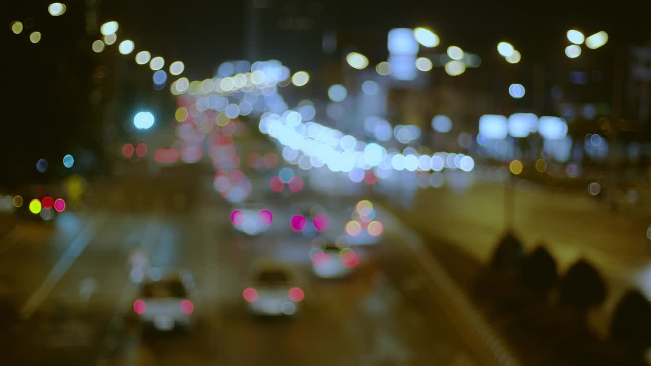 城市交通十字路口夜间车灯散景环光和失焦背景。视频素材