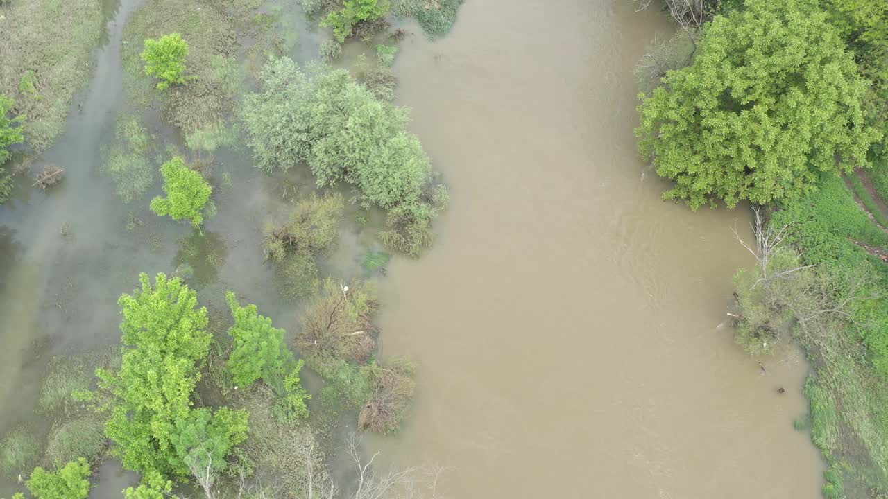 在大雨后带着脏水的河流上空飞行的4K无人机视频视频素材