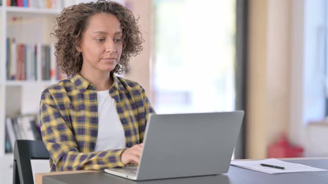 积极的混血儿女人与笔记本显示大拇指向上视频素材