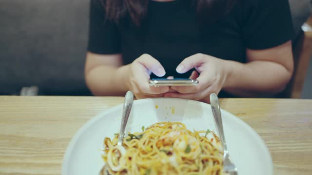 在餐厅用智能手机拉近女人的手视频素材