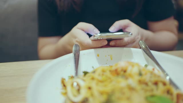 在餐厅用智能手机拉近女人的手视频素材