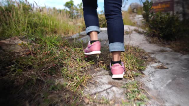 在山上徒步旅行的女人的脚上的观点视频素材