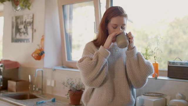 女人独自在厨房喝茶视频素材