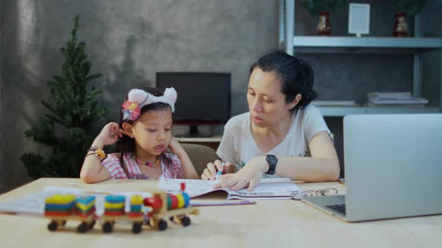 女儿和她的母亲学习教育，而年轻的女人在公寓工作视频素材