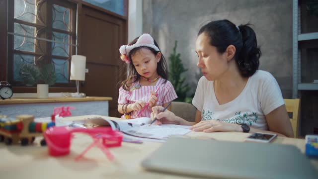 女儿和她的母亲学习教育，而年轻的女人在公寓工作视频素材