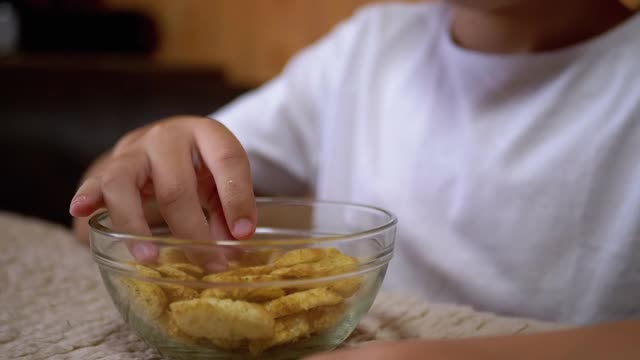 小孩的手从盘子里拿饼干。食用有害的零食。快餐视频素材