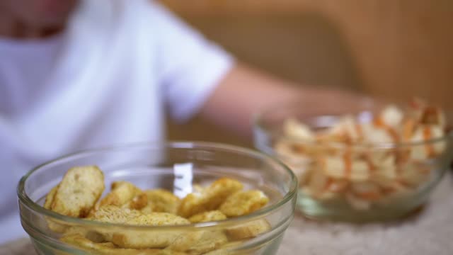 小孩的手从盘子里拿薯条，饼干。吃有害的零食视频素材