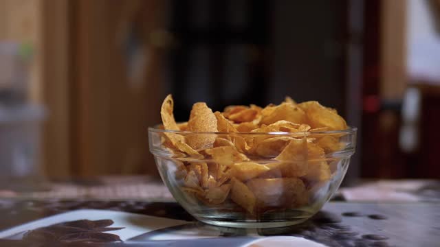 饥饿的青少年在没人看见的情况下从盘子里偷薯片视频素材