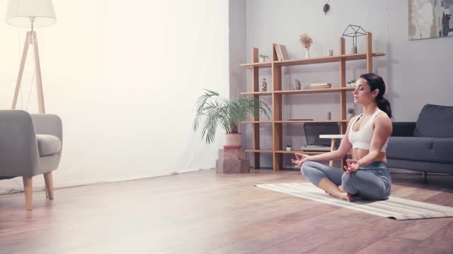 年轻女子沉思在莲花姿势在家视频素材