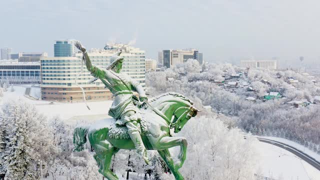 冬季无人机拍摄的萨拉瓦特·尤拉耶夫纪念碑、toratau大楼(国会大厅)、蒙古包和城市建筑。晴朗的冬日，蔚蓝的天空。近距离视频素材