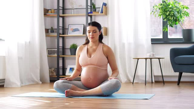 一名孕妇在家冥想莲花姿势视频素材