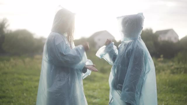 在雨天的夏天，快乐的孩子们在阳光下玩石头剪子布。积极开朗的白人男孩和女孩在户外玩。快乐的童年和友谊的概念视频素材