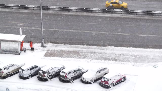 时间流逝。从上面看到公交车站和清理人行道积雪的工人视频下载