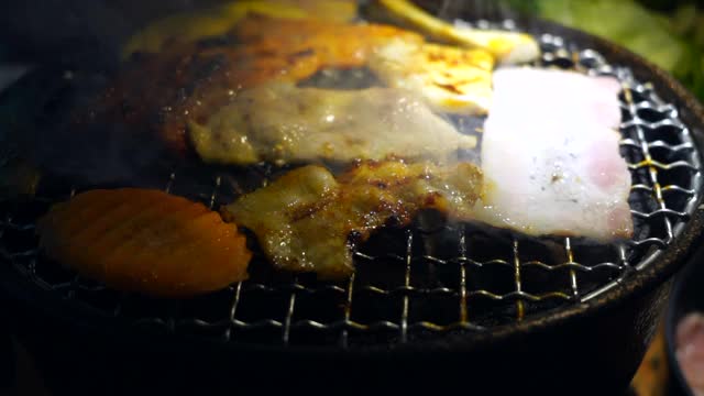 韩式烧烤，日式烧肉，特写。晚餐,新鲜。肉在木炭炉上烤。视频素材