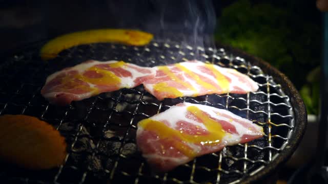 韩式烧烤，日式烧肉，特写。晚餐,新鲜。肉在木炭炉上烤。视频素材