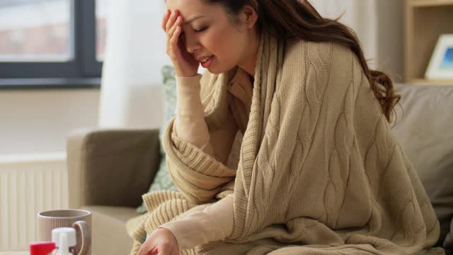 悲伤生病的亚洲女人在家里喝热茶视频素材