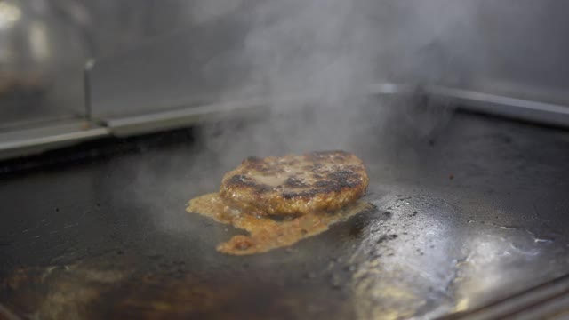 煮牛肉和猪肉肉饼做汉堡。肉在厨房烤。缓慢的运动。视频素材